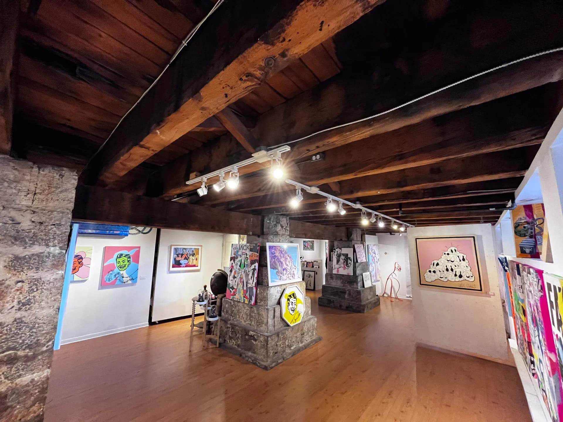 Room at the 163 Saint-Paul West gallery, wooden beams and stone pillars