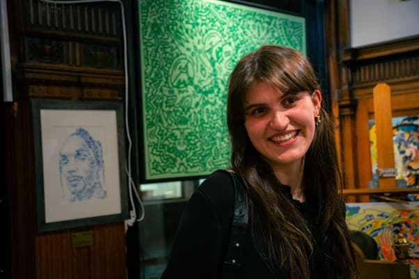 Bénévole dans une galerie d'art entouré d'œuvres colorées