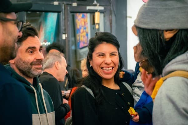 Bénévole dans une galerie d'art entouré d'œuvres colorées