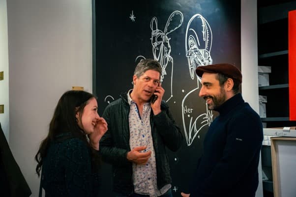 Bénévole dans une galerie d'art entouré d'œuvres colorées