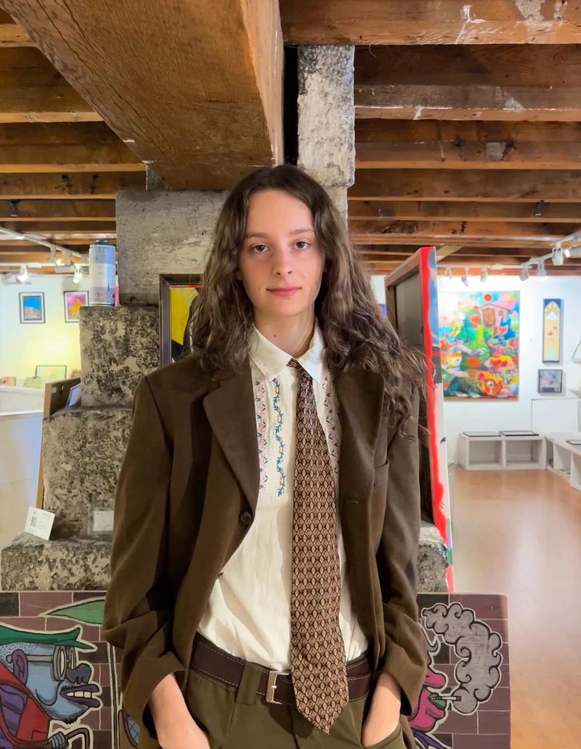 Bénévole dans une galerie d'art entouré d'œuvres colorées