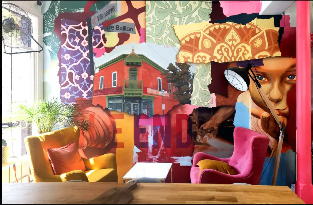 A bright lounge with a colorful collage mural and two armchairs
